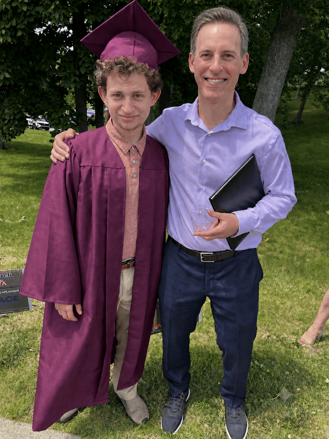 Father and graduate celebrating outdoors